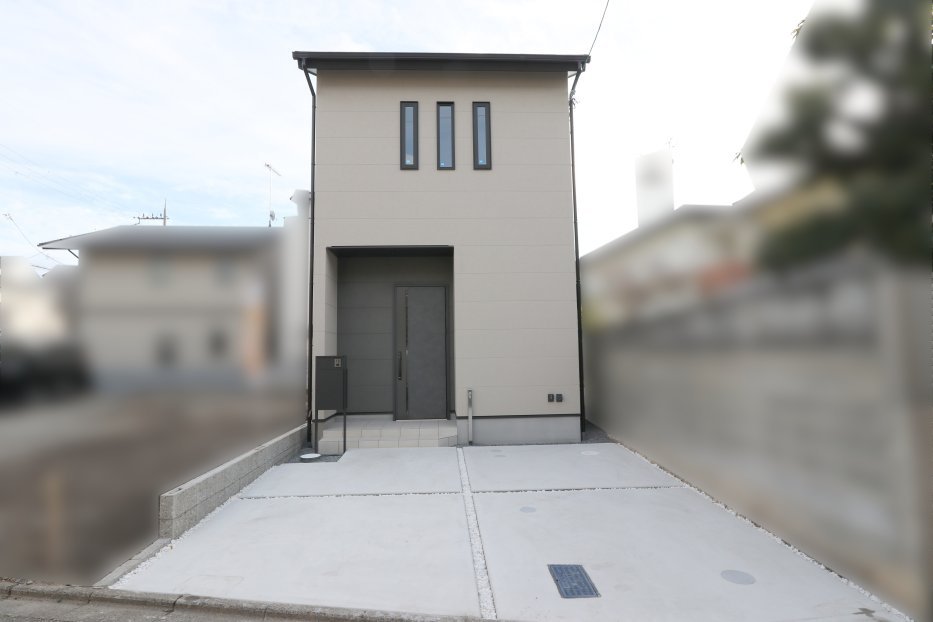 明るめの外壁カラー（ベージュ系） が使われており、清潔感と落ち着きが感じられます。縦にスリット窓を3本並べたデザインが特徴的で、シンプルながらもスタイリッシュな印象を与えています。