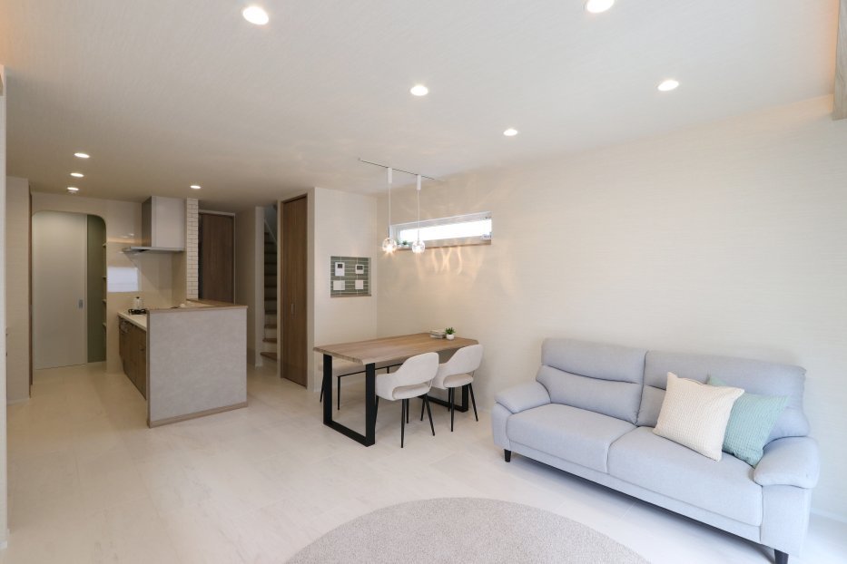 木目を基調にしたナチュラルテイストのLDKは、明るく開放感のある空間に。 間接照明やダウンライトが、昼も夜も心地よい雰囲気を演出します。 キッチンは使いやすい動線設計で、収納も豊富。